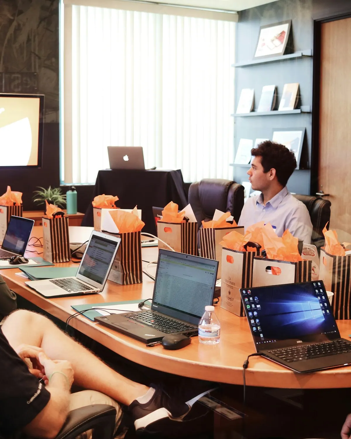 A facilitator presenting to a small group of business owners with laptops open